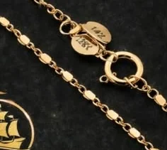 Detalle del broche de una cadena con el sello 18K grabado.