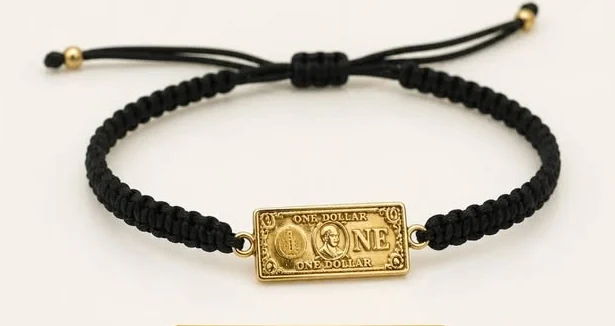 Pulsera de hilo macramé negro con una placa dorada grabada One Dollar.